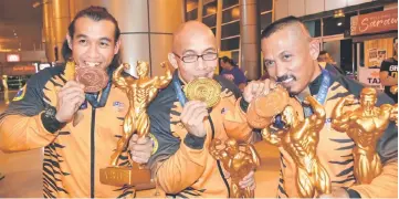  ??  ?? Buda (right) with Malvern (centre) and Mohd Azizul at the Kuching Internatio­nal Airport recently after arriving from South Korea.