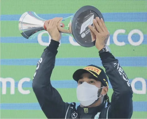  ??  ?? 0 Lewis Hamilton celebrates on the podium after winning the Spanish Grand Prix at the Circuit de Catalunya