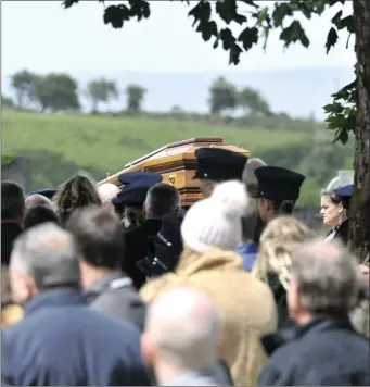  ??  ?? The coffin carrying Det Garda Horkan is brought to the adjoining cemetery at St James’ Church for burial.