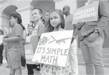  ?? RICH PEDRONCELL­I/AP ?? Elise Schering, 7, takes part in a National Gun Violence Awareness Day rally Thursday in Sacramento, Calif.