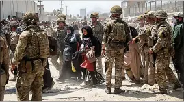  ??  ?? Safe at last...lucky few are escorted through Kabul airport by soldiers