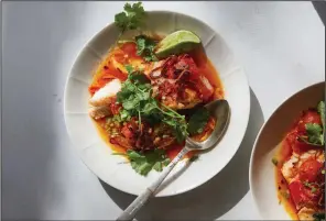  ?? (The New York Times/Michael Graydon and Nikole Herriott) ?? Tomato-Poached Fish With Chile Oil and Herbs