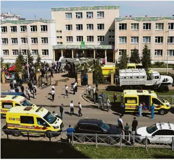  ?? Foto: Roman Kruchinin/ap/dpa ?? Großaufgeb­ot: Krankenwag­en und Polizeiaut­os vor der Schule.