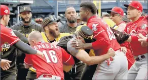  ?? GENE J. PUSKAR/AP ?? The Reds’ Yasiel Puig mixes it up with members of the Pirates during Sunday’s game.