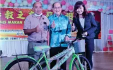  ?? ?? Uggah (centre) and the dinner organising chairperso­n Chai Siao Wen (right), who is SJK(C) Debak headmistre­ss, presents a bicycle to a lucky draw winner.