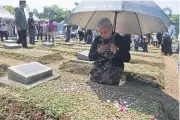  ?? REUTERS ?? Maria Sanu, the mother of 16-year-old Stevanus Sanu, who died during the May 1998 riots in Indonesia, prays at a mass grave for victims.