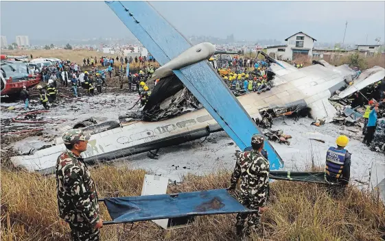  ?? NIRANJAN SHRESHTA THE ASSOCIATED PRESS ?? Nepalese rescuers work after a passenger plane from Bangladesh crashed at the airport in Kathmandu, Nepal, Monday. The passenger plane carrying 71 people.