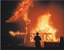  ?? Noah Berger Associated Press ?? A HOME burns in Paradise, one of 1,000 structures destroyed by a wildfire that rapidly grew from 10 acres to more than 10,000 acres.