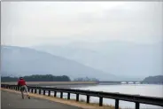  ?? TANIA BARRICKLO — DAILY FREEMAN ?? An in-line skater zips along the shore of the Ashokan Reservoir in the town of Olive, N.Y., on Wednesday, Jan. 13. A thin layer of snow covers the mountains in the distance.