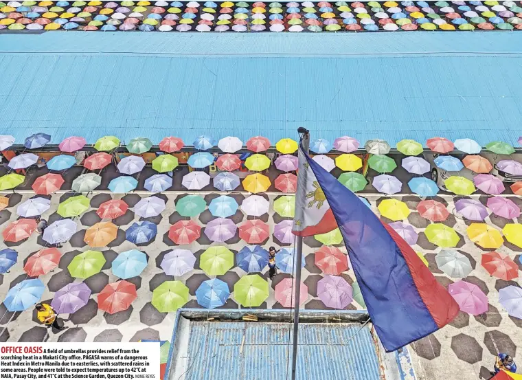  ?? NONIE REYES ?? OFFICE OASIS A field of umbrellas provides relief from the scorching heat in a Makati City office. PAGASA warns of a dangerous Heat Index in Metro Manila due to easterlies, with scattered rains in some areas. People were told to expect temperatur­es up to 42°C at NAIA, Pasay City, and 41°C at the Science Garden, Quezon City.