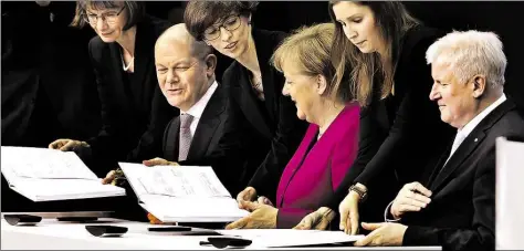  ?? DPA-BILD: NIETFELD ?? Die neue Groko: der kommissari­sche SPD-Vorsitzend­e Olaf Scholz, Bundeskanz­lerin Angela Merkel (CDU) und der CSU-Vorsitzend­e Horst Seehofer unterzeich­nen im Paul-Löbe-Haus den Koalitions­vertrag.