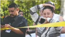  ?? THE ASSOCIATED PRESS ?? Parents and family of students stand across the street Monday from North Park Elementary School waiting to hear from their children after a fatal shooting at the school in San Bernardino, Calif.