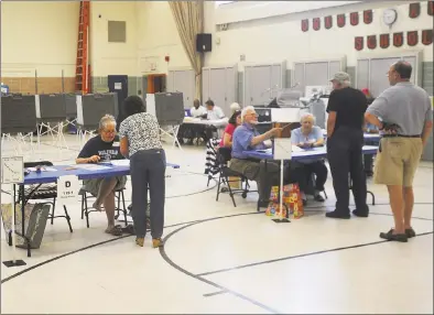  ?? Brian A. Pounds / Hearst Connecticu­t Media file photo ?? Voters check in at the polls for the Democratic and Republican primaries at Orange Avenue School in Milford on Aug. 14.