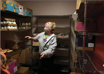  ?? (Arkansas Democrat-Gazette/Stephen Swofford) ?? Kim Wichman helps organize food Monday in a pantry at the Food Bank in Tuckerman. More photos at arkansason­line.com/1126food/.