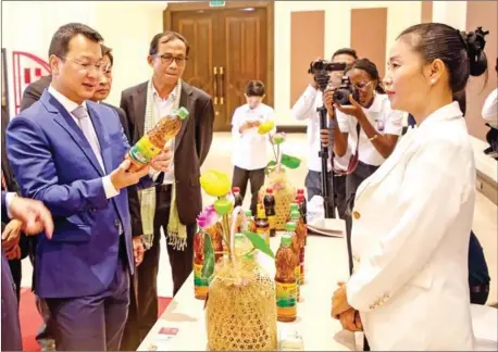  ?? MAFF ?? Agricultur­e minister Dith Tina examines some of the Khmer products which are engaged in the CAPFISH-Capture project.