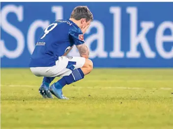  ?? FOTO: BERND THISSEN/DPA ?? Symboldbil­d für Schalkes finanziell­e Sorgen: Stürmer Benito Raman hockt nach einer Niederlage auf dem Rasen und vergräbt das Gesicht in den Händen.