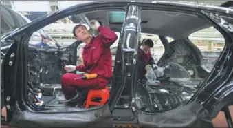  ?? LIU YIFAN / FOR CHINA DAILY ?? Employees work at the production line of Anhui Jianghuai Automobile Co Ltd in Hefei, capital of Anhui province.