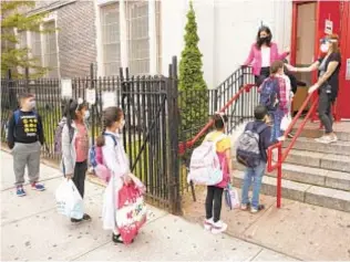  ?? ?? Students get temps checked before going into Public School 179 in Brooklyn. Schools face staff shortages as thousands of employees have yet to get vaccinated ahead of Monday deadline.