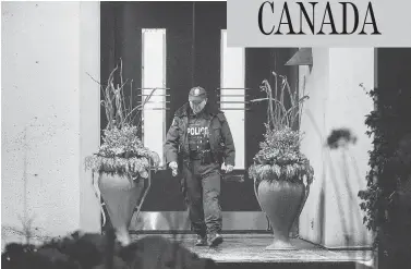  ?? PETER J THOMPSON / NATIONAL POST ?? An officer leaves the north Toronto home of philanthro­pists Honey and Barry Sherman. Both were found dead.