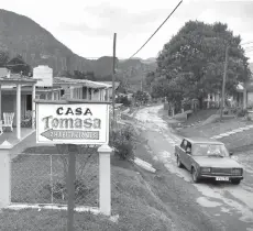  ??  ?? A car passes by a singage of a private house for rent in Vinales, Cuba.