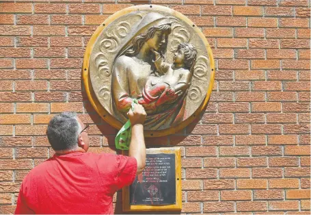  ?? JIM WELLS ?? Volunteer and Knights of Columbus member Ryan Desrosiers cleans graffiti at St Bonaventur­e Catholic Church in Calgary on Thursday. Polce say several city churches, mostly Catholic, were targeted on Canada Day in reaction to the deaths of Indigenous children in residentia­l schools.