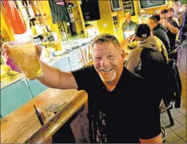  ??  ?? Marvin Radtke toasts the opening of the Friends and Neighbors bar in Appleton, Wis., following the decision to strike down the state’s pandemic restrictio­ns.