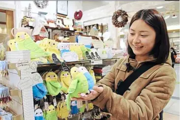  ??  ?? hello, birdy: A woman holds parakeet bags on the palm of her hand at Plame Collome at JR Ueno Station in Tokyo.