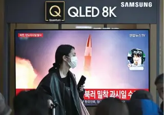  ?? ?? A woman walks past a television showing a news broadcast, with file footage of a North Korean missile test, at a railway station in Seoul on March 18, 2024. (Photo by Anthony WALLACE / AFP)