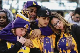  ?? RINGO H.W. CHIU/AP ?? Fans pay respect at a memorial for Kobe Bryant near Staples Center Monday in Los Angeles. Bryant, the 18-time NBA All-Star who won five championsh­ips during a 20-year career with the Los Angeles Lakers, died in a helicopter crash Sunday.