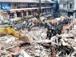  ??  ?? — PTI Fire brigade and NDRF personnel carry out search and rescue operations following the collapse of a building at Pakmodiya Street in South Mumbai on Thursday.