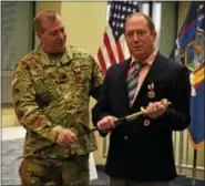  ?? PFC. ANDREW VALENZA - NEW YORK NATIONAL GUARD ?? N.Y. Army National Guard Lt. Col. Joseph Claus, left, presents his brother, Master Sgt. Leonard Claus with a ceremonial Non-Commission­ed Officer’s Sword, during their retirement ceremony Dec. 2in Latham. The brothers had a combined 63years of service.