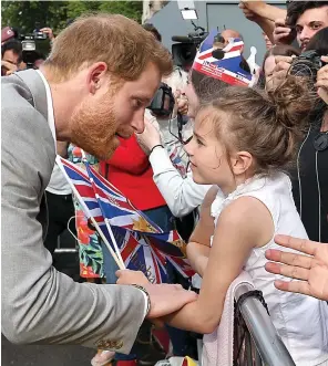  ??  ?? Touching moment: Harry places a hand on a young girl’s arm