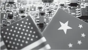  ?? Reuters-Yonhap ?? Flags of China and U.S. are displayed on a printed circuit board with semiconduc­tor chips, Feb. 17, 2023.