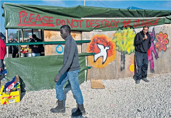  ??  ?? Graffiti on a makeshift building that will be razed this week when bulldozers move into the Jungle migrant camp in Calais. The French government is to dismantle the settlement and relocate more than 6,000 residents