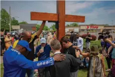  ?? ?? A group prays at the site of a memorial for the victims of the Buffalo supermarke­t shooting outside the Tops Friendly Market on Saturday, May 21, 2022, in Buffalo, N.Y.