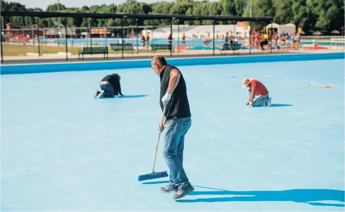  ?? EFE ?? Un operario limpia una de las piscinas pertenecie­ntes a la Comunidad de Madrid