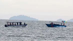  ??  ?? Ongoing mission: Search and rescue personnel trawling the sea off
Tanjung Bungah.