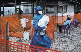  ?? The Associated Press ?? In this photo taken Nov. 4 and made available Tuesday, a caretaker already cured of Ebola carries a 4-day-old baby suspected of having the disease into a treatment center in Butembo, Congo.