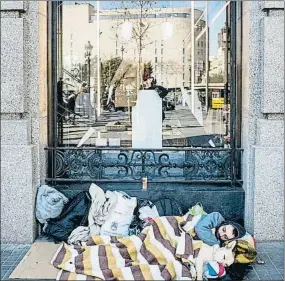  ?? XAVIER CERVERA ?? Un hombre y su perro duermen en la calle, junto a la plaza Catalunya