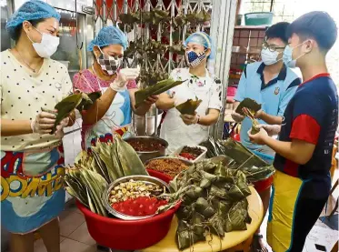  ?? LIM BenG TaT/The star ?? Family business: (from left) Helen, Choy Pin, Rinis, Lee Wei Cher, 19, and ng Kai Wei, 15, wrapping dumplings at the Pin Village Restaurant in Bukit Mertajam, Penang. —