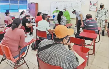  ??  ?? Sentados en los pupitres de los alumnos, los docentes esperaron pacienteme­nte su turno para que les pusieran la vacuna contra el Covid-19, en lo que fue el primer día de vacunación a profesores en Oaxaca.