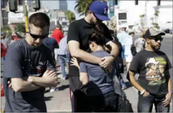  ?? MARCIO JOSE SANCHEZ — THE ASSOCIATED PRESS ?? Reed Broschart, center, hugs his girlfriend Aria James on the Las Vegas Strip in the aftermath of a mass shooting at a concert Monday in Las Vegas. The couple, both of Ventura attended the concert.