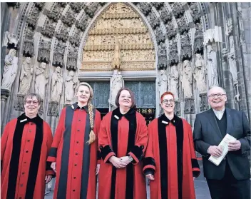  ?? FOTO: OLIVER BERG/DPA ?? Die neuen Domschweiz­erinnen Heidi Michels, Andrea Petzenhaus­er, Susanne Rückes und Claudia Drolshagen (v.l.) sowie Dompropst Gerd Bachner stehen vor dem Portal des Kölner Doms.