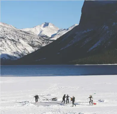  ?? MARIE CONBOY/POSTMEDIA; AZIN GHAFFARI/POSTMEDIA ?? Ice skaters on Lake Minnewanka in Banff National Park on Jan. 13. Four people fell through the ice last weekend and
one required a thin ice rescue response from Banff Visitor Safety. Below, a cross-country skier in Calgary.