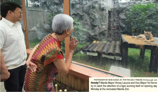  ?? PHOTOGRAPH BY BOB DUNGO JR. FOR THE DAILY TRIBUNE @tribunephl_bob ?? Howdy? Manila Mayor Honey Lacuna and Vice Mayor Yul Servo try to catch the attention of a tiger sunning itself on opening day Monday at the renovated Manila Zoo.