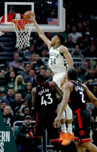  ?? Jonathan Daniel/Getty Images ?? The Bucks’ Giannis Antetokoun­mpo dunks past Toronto’s Pascal Siakam in the first quarter of Game 2 of the Eastern Conference Finals Friday in Milwaukee.