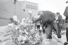  ?? ARMANDO L. SANCHEZ/CHICAGO TRIBUNE ?? A man touches a cross after attending a vigil Sunday outside the Henry Pratt Co. plant.