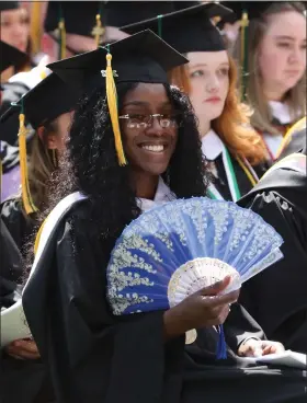  ?? ?? Heaven-leigh Daniel of Fitchburg, graduating with a Bachelor of Science degree in communicat­ions media, fans herself to stay cool at Fitchburg State University’s Commenceme­nt on Saturday.