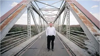  ??  ?? SIMON Roche stands on a bridge over the Orange River.