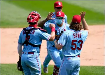 ?? AP Photo/Charles Rex Arbogast ?? St. Louis Cardinals catcher Andrew Knizner (left) and relief pitcher John Gant fake a high five with Kolten Wong after the Cardinals 5-1 win over the Chicago White Sox in Game 1 of a double-header baseball game on Saturday.